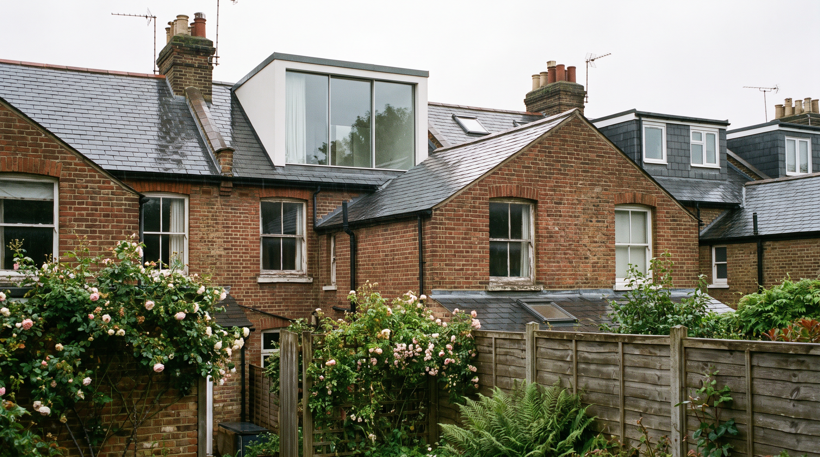 Rear box dormer loft conversion on a two-storey house, its vertical window face set back from the eaves of the existing tiled roof.
